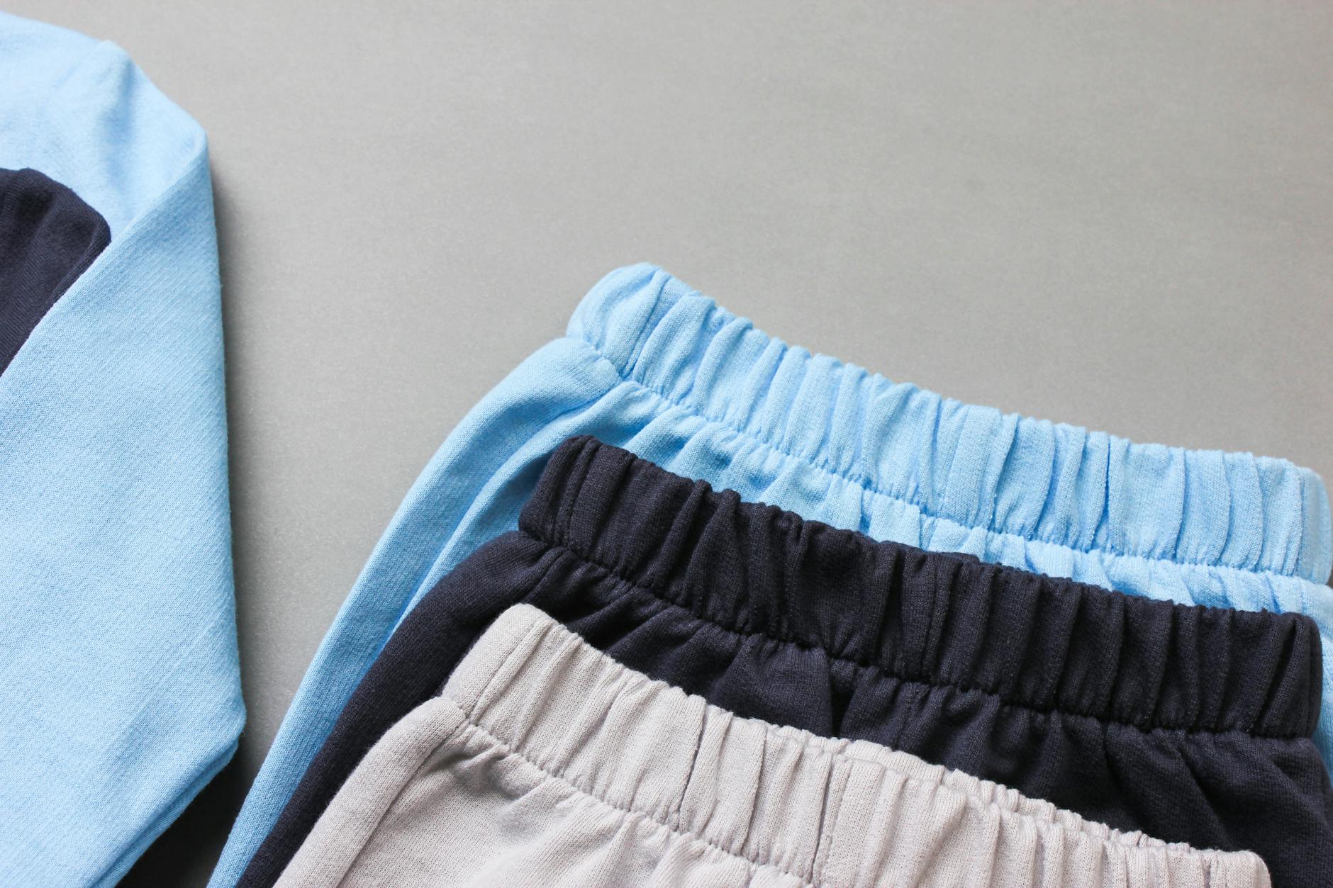 Pastelowe ubranka niemowlęce z miękkiej bawełny ułożone na płasko