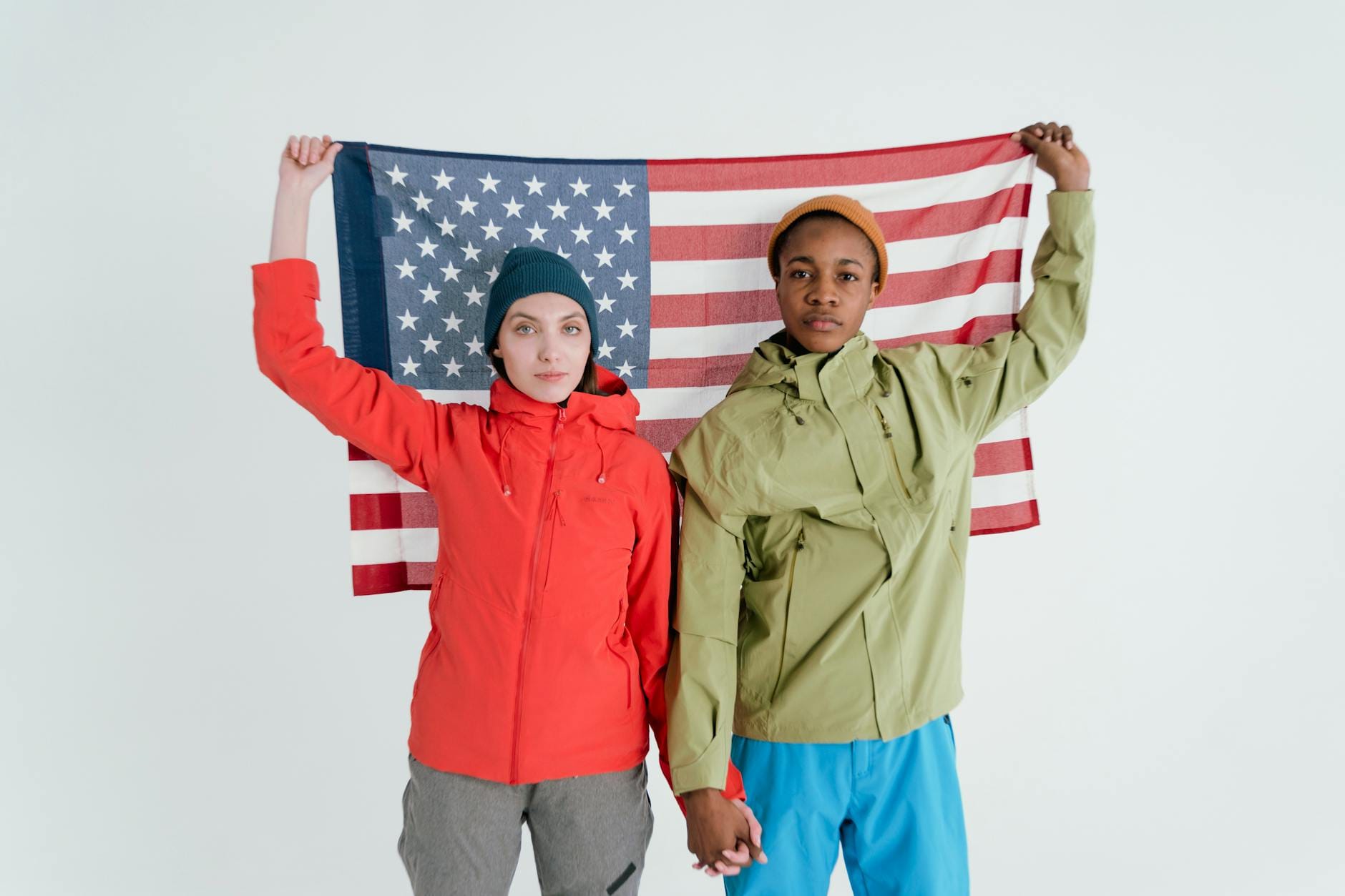 Dwójka młodych dorosłych trzyma amerykańską flagę w studiu