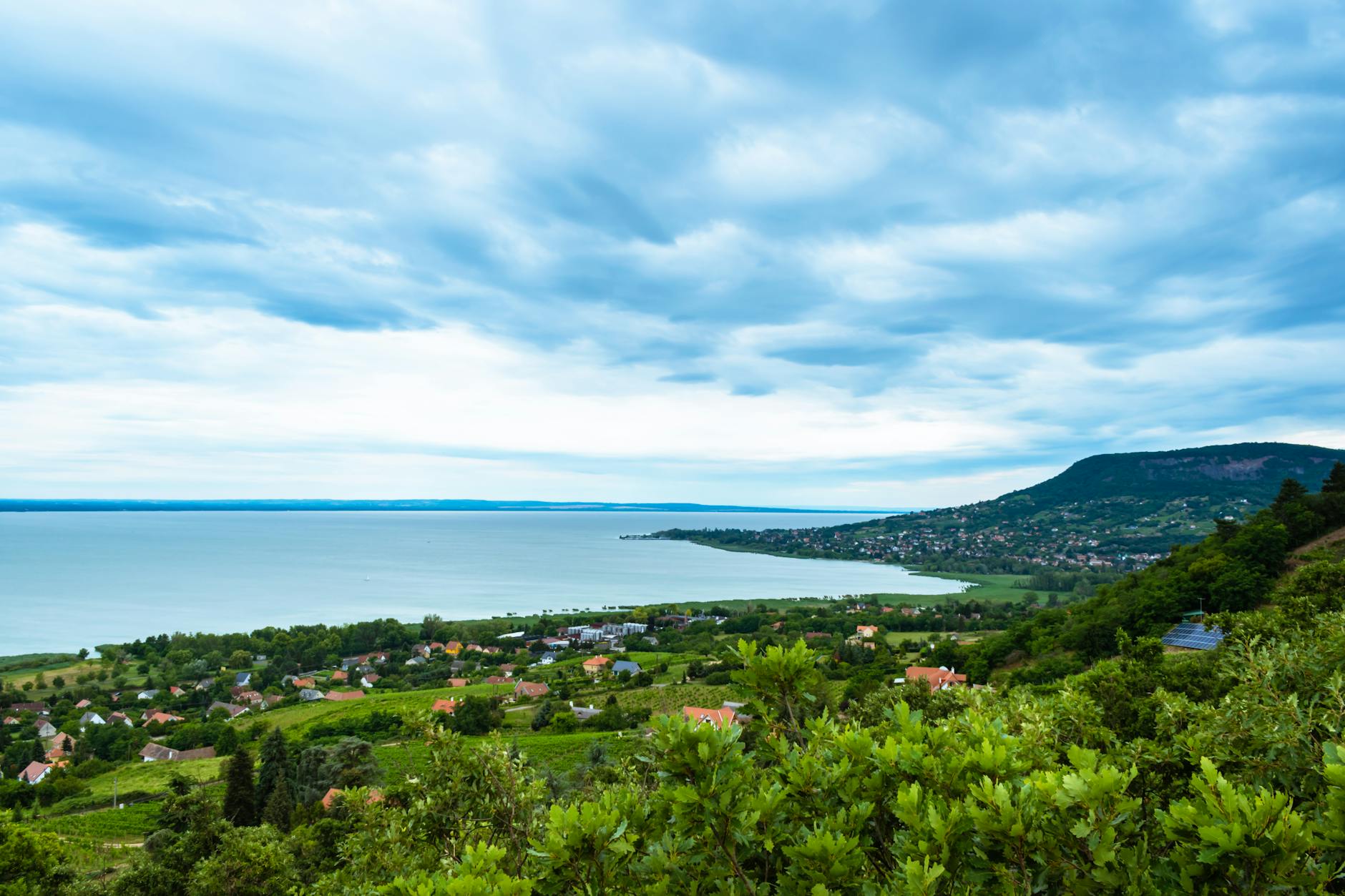Szlak małych winiarni nad Balatonem: gdzie spać, co jeść i z kim rozmawiać po drodze Panorama Badacsonytomaj i jeziora Balaton pod pochmurnym niebem