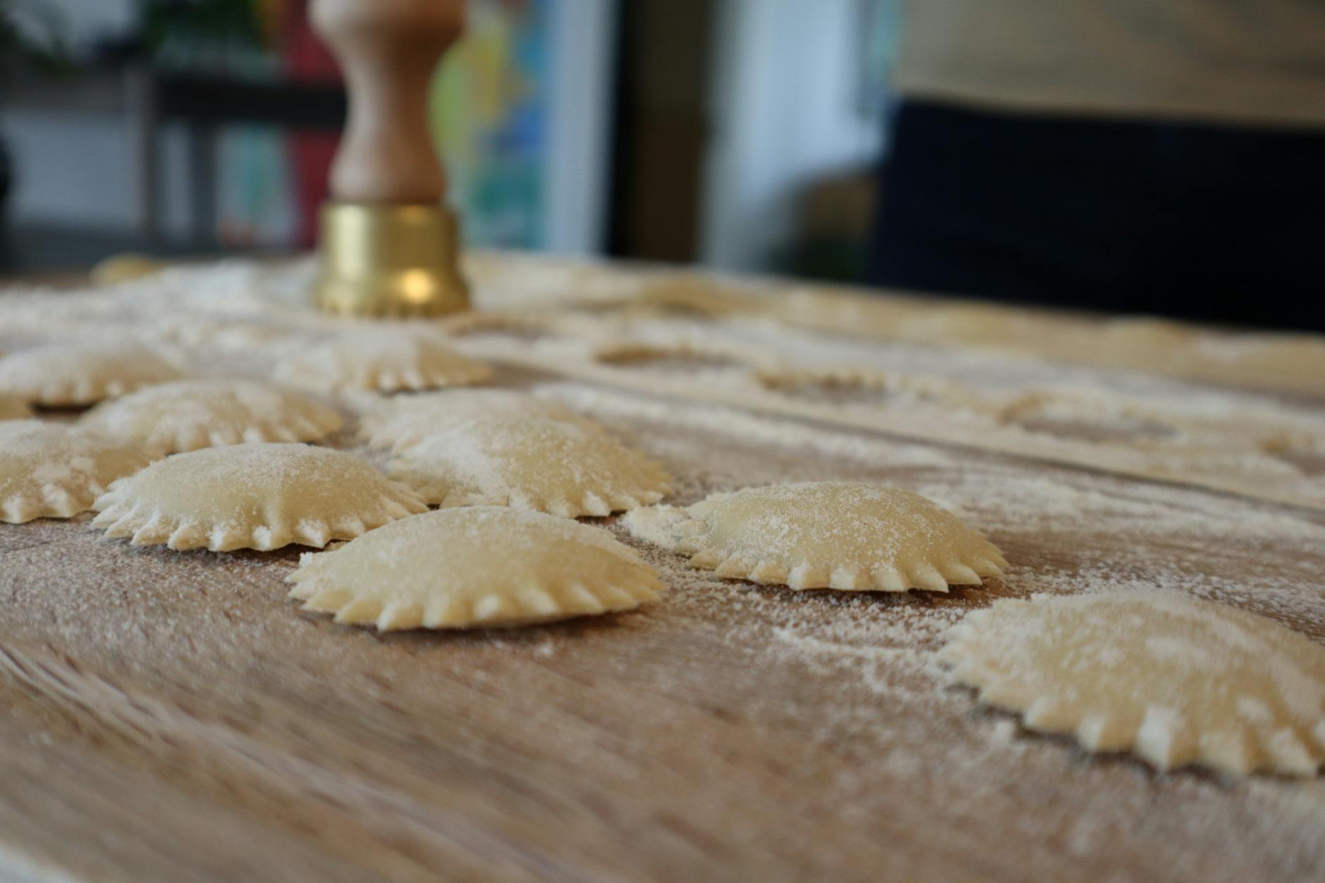 Świeże, surowe ravioli ułożone na podsypanej mąką desce