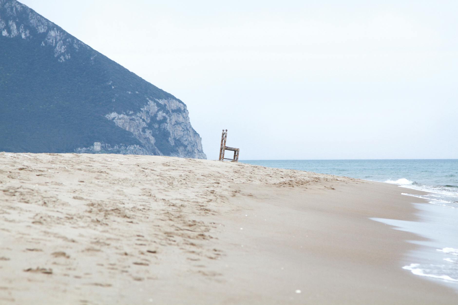 Spokojna włoska plaża z górami w tle i bezludnym, cichym morzem Spokojna włoska plaża z górami w tle i bezludnym, cichym morzem