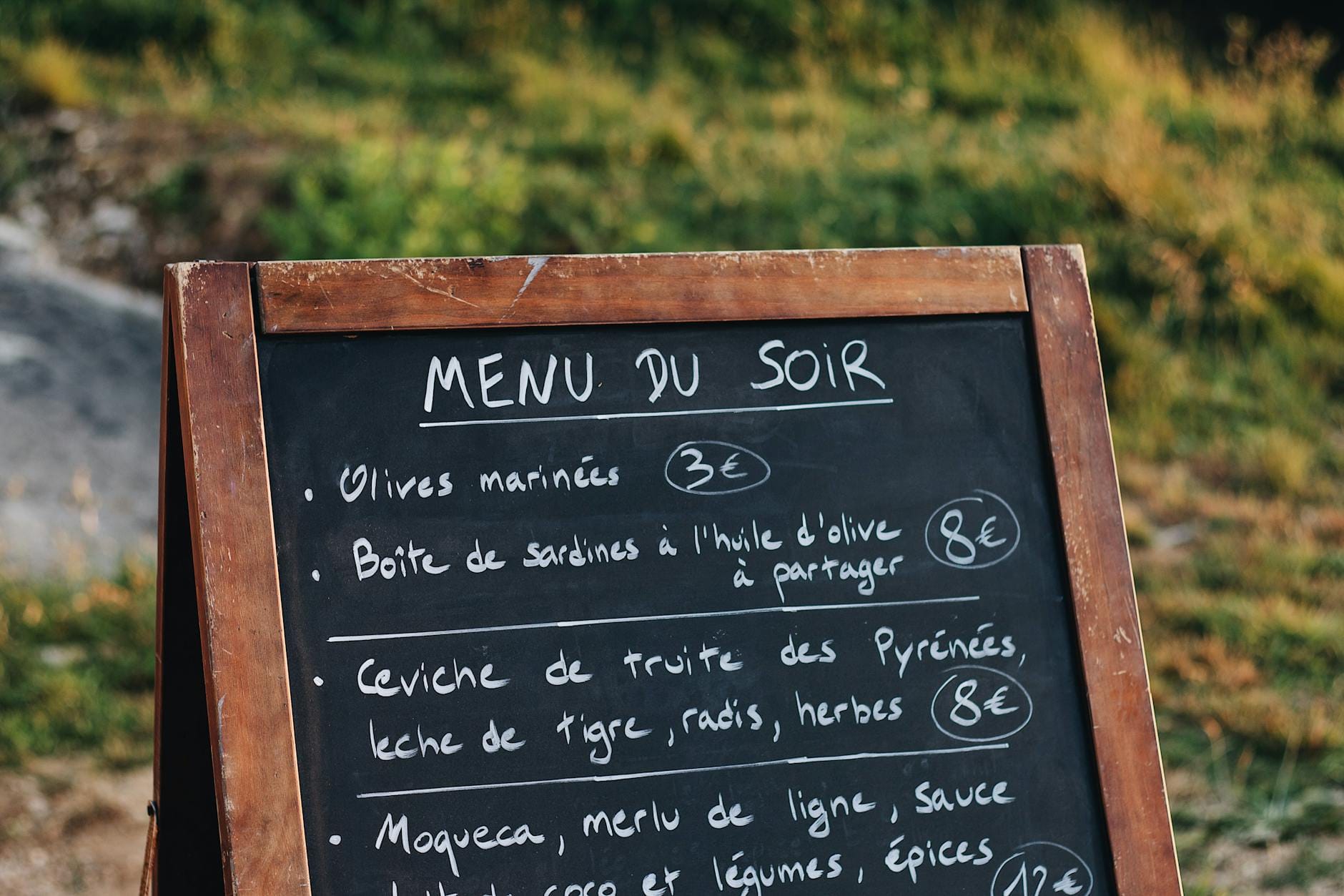 Jak czytać francuską kartę dań, by zamawiać jak lokalny i nie przepłacać Stojąca na ulicy tablica z francuskim menu i cenami