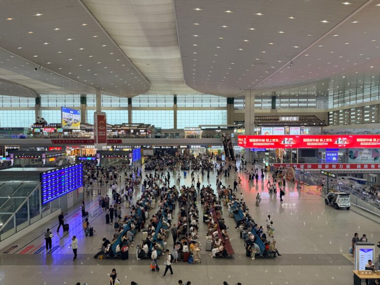 Tłum podróżnych i oznakowanie na dworcu Chengdu East w Chinach